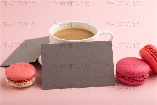 Gray paper business card mockup with red and purple macaroons and cup of coffee on pink pastel