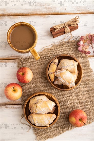 Homemade sweet cookie with apple jam and cup of coffee on white wooden background and linen textile