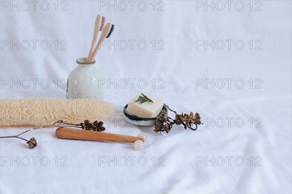 Eco-friendly personal care items with toothbrushes and soap dish on a white background, conveying a