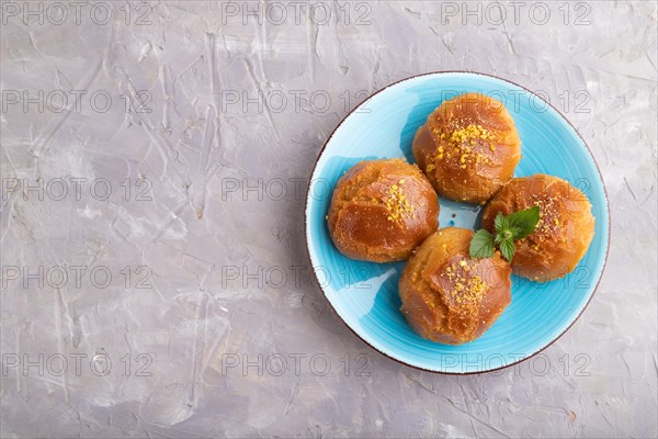 Homemade traditional turkish dessert sekerpare with almonds and honey on gray concrete background.