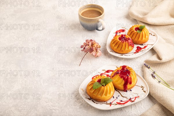 Semolina cheesecake with strawberry jam, lavender, cup of coffee on gray concrete background and