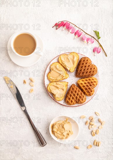 Homemade waffle with peanut butter and cup of coffee on a gray concrete background. top view, flat