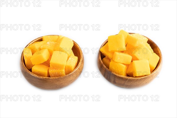 Dried and candied mango cubes in wooden bowls isolated on white background. Side view, close up,
