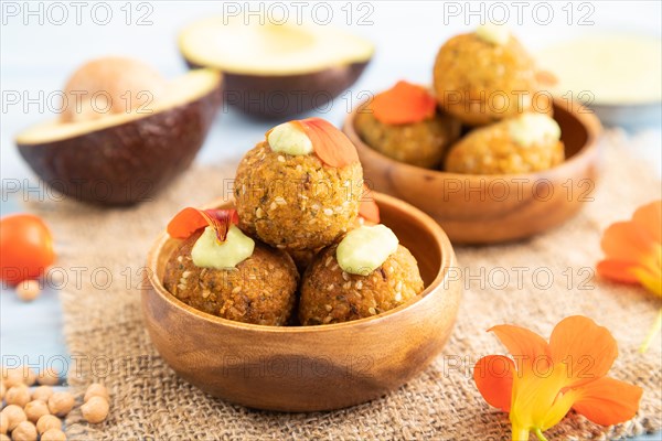 Falafel with guacamole on blue wooden background and linen textile. Side view, close up, selective