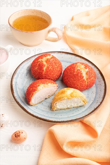 Traditional french custard dessert shu cake and cup of green tea on white wooden background and