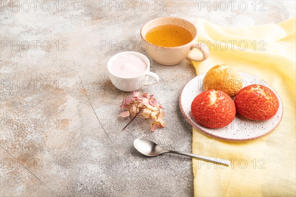 Traditional french custard dessert shu cake and cup of green tea on brown concrete background and