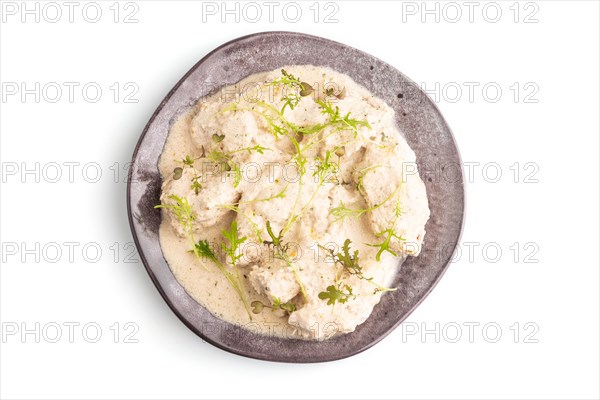 Stewed chicken fillets with coconut milk sauce and mizuna cabbage microgreen isolated on white
