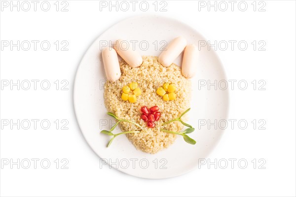 Funny mixed quinoa porridge, sweet corn, pomegranate seeds and small sausages in form of cat face