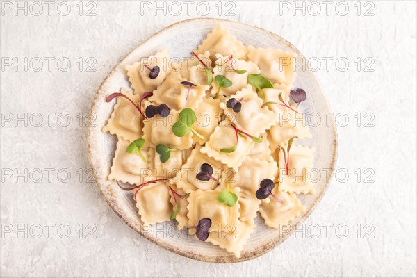 Dumplings with pepper, salt, herbs, microgreen on gray concrete background. Top view, flat lay,