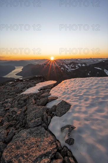 View of mountains and fjord Faleidfjorden, sun star at sunset, summit of Skala, Loen, Norway,