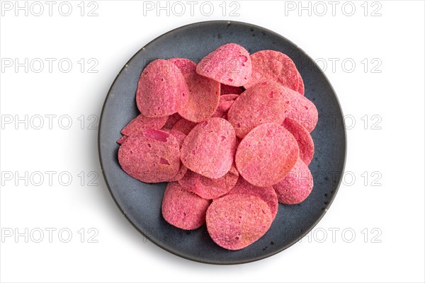 Red potato chips with herbs and tomatoes on blue cearmic plate isolated on white background. Top