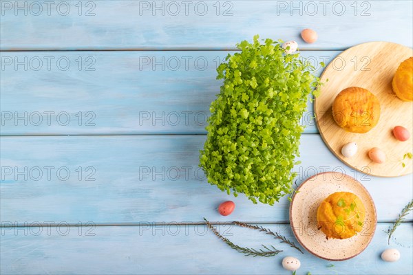 Homemade cakes with chocolate eggs and spinach microgreen on a blue wooden background. top view,