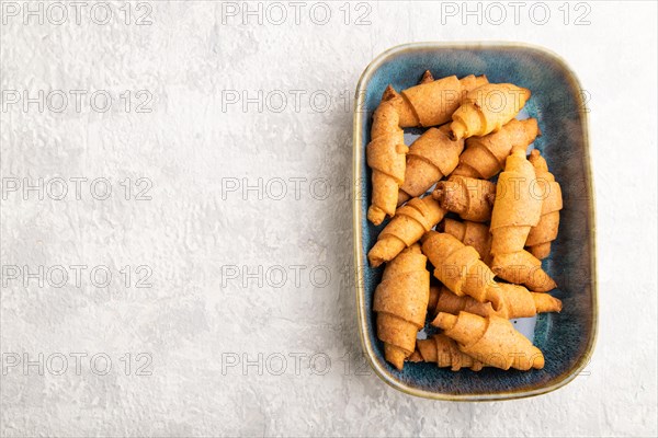 Homemade bagel roll on blue ceramic plate on gray concrete background. top view, flat lay, copy
