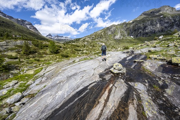 Mountaineers on a hiking trail in front of a picturesque mountain landscape, rocky mountain peaks
