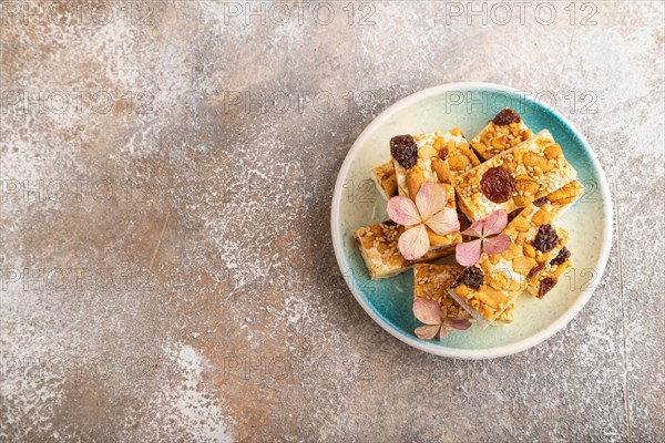 Traditional candy nougat with nuts and sesame on brown concrete background. top view, flat lay,