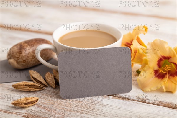 Gray paper business card mockup with orange day-lily flower and cup of coffee on white wooden