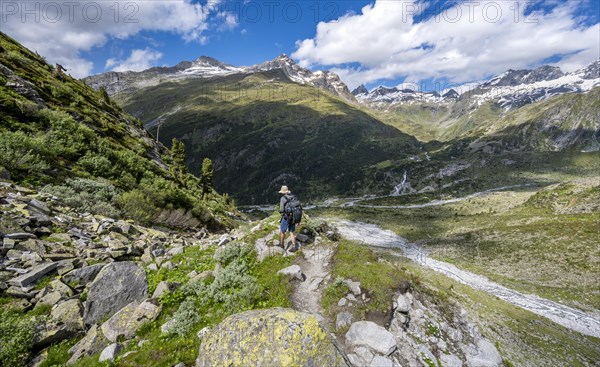 Mountaineers on a hiking trail in front of a picturesque mountain landscape, rocky mountain peaks