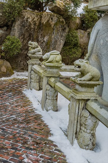 Stone carved dragon, rabbit and bear that represents the Chinese horoscope, on concrete fence in