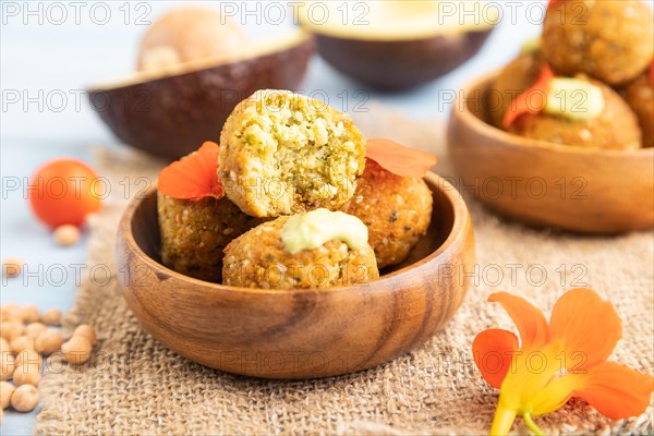 Falafel with guacamole on blue wooden background and linen textile. Side view, close up, selective