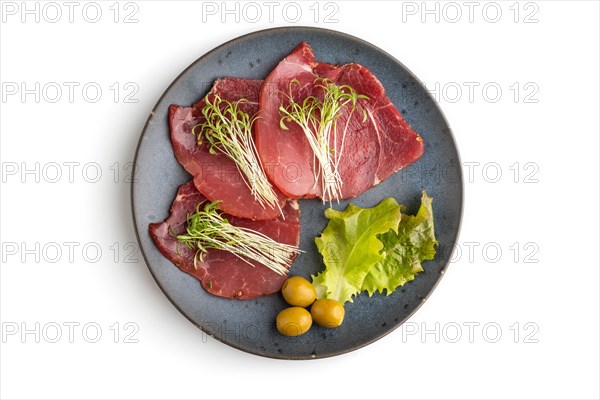 Slices of smoked salted meat with cilantro microgreen isolated on white background. Top view, flat