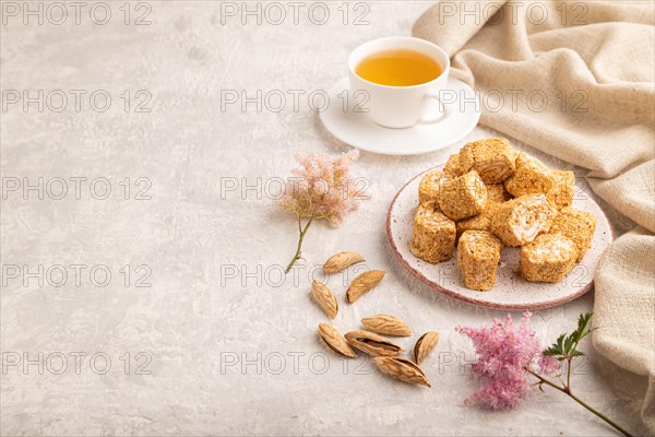 Traditional turkish delight (rahat lokum) with cup of green tea on a gray concrete background and