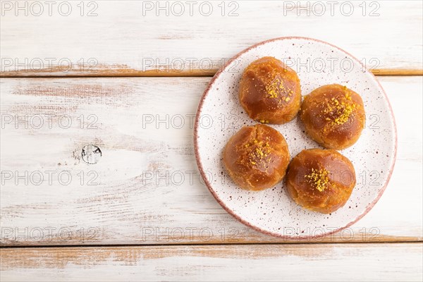 Homemade traditional turkish dessert sekerpare with almonds and honey on white wooden background.