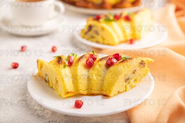 Cheesecake with cup of green tea on gray concrete background and orange linen textile. side view,