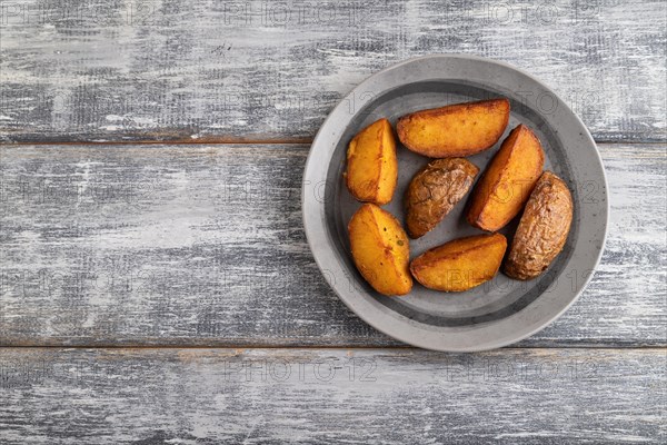 Heap of fried potato on a gray plate on a gray wooden background. Top view, flat lay, close up,