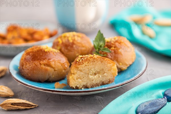 Homemade traditional turkish dessert sekerpare with almonds and honey, cup of green tea on gray