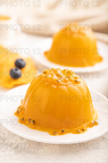 Mango and passion fruit jelly with blueberry on gray concrete background and linen textile. side