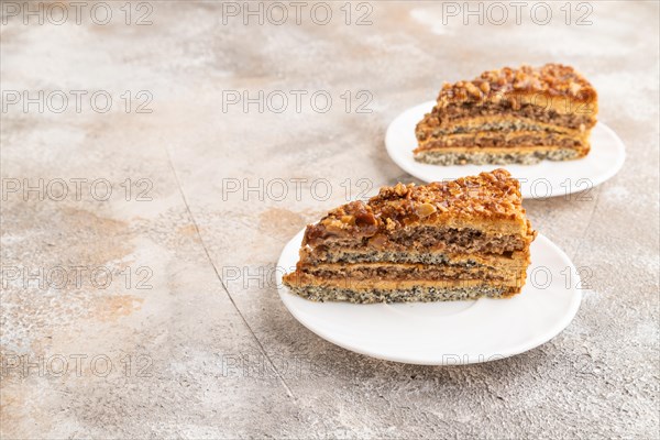 Walnut and hazelnut cake with caramel cream on brown concrete background. side view, copy space
