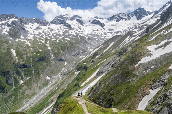 Mountaineer on hiking trail in picturesque mountain landscape, in the background mountain peak