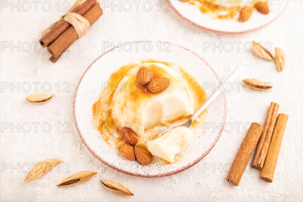 White milk jelly with caramel sauce on gray concrete background. side view, close up, selective