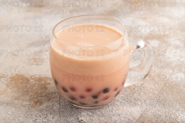 Bubble tea with pistachio and caramel in glass on brown concrete background. Healthy drink concept.