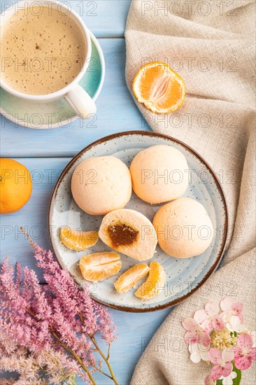 Japanese rice sweet buns mochi filled with tangerine jam and cup of coffee on a blue wooden