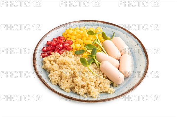 Mixed quinoa porridge, sweet corn, pomegranate seeds and small sausages isolated on white