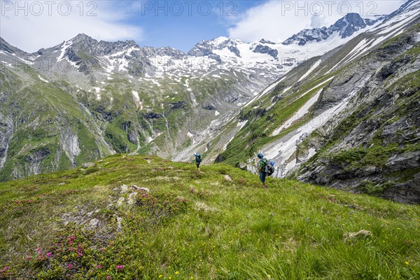 Mountaineer on hiking trail in picturesque mountain landscape, in the background mountain peak