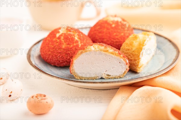 Traditional french custard dessert shu cake and cup of green tea on white wooden background and