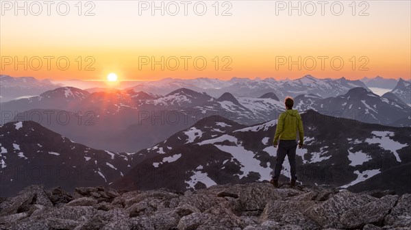 Mountaineer enjoying the view, mountain panorama at the summit of Skala at sunset, sun setting