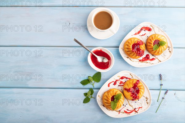 Semolina cheesecake with strawberry jam, lavender, cup of coffee on blue wooden background. top
