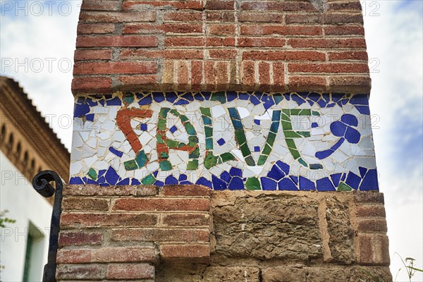 Greeting salute at Casa Trias, tiles with inscription, mosaic, Trencadis, Park Gueell, Barcelona,