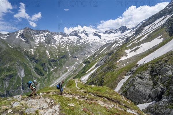 Mountaineer on hiking trail in picturesque mountain landscape, in the background mountain peak