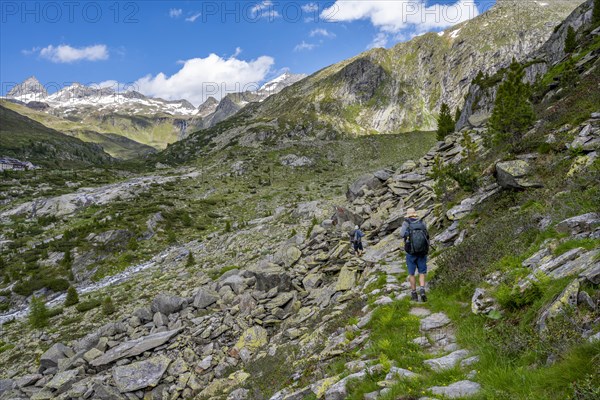 Mountaineers on a hiking trail, behind mountain peaks Zsigmondyspitze and Hornkeesbach near the