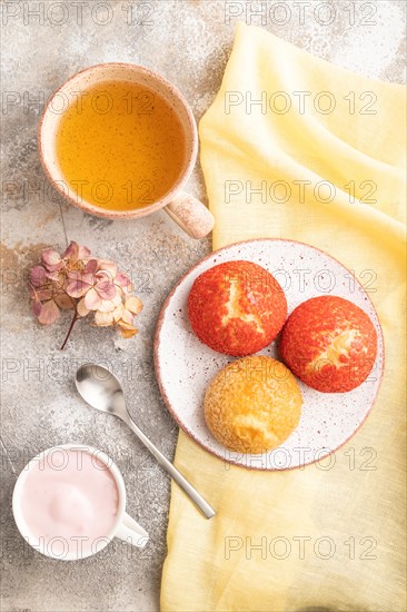 Traditional french custard dessert shu cake and cup of green tea on brown concrete background and