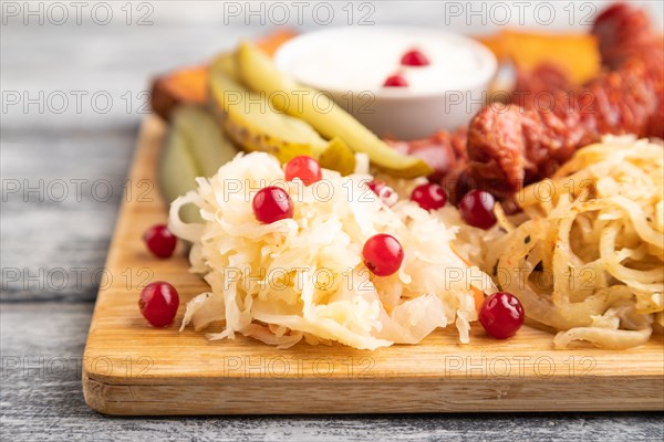 Set of snacks: sausages, toast, sauerkraut, marinated onion and cucumber, baked potato on a cutting