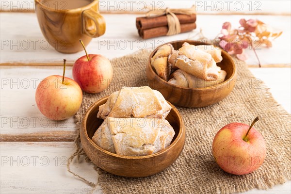 Homemade sweet cookie with apple jam and cup of coffee on white wooden background and linen textile