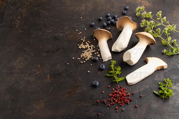 King Oyster mushrooms or Eringi (Pleurotus eryngii) on black concrete background with blueberry,