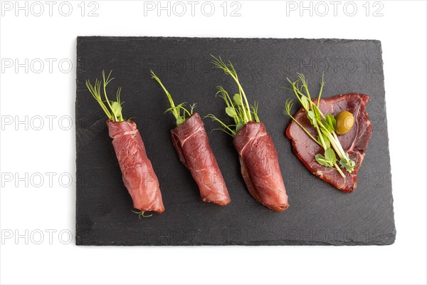 Slices of smoked salted meat with green pea microgreen isolated on white background. Top view, flat