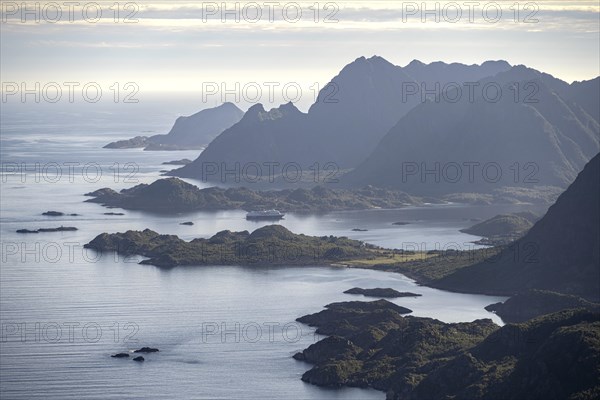 View of the coast in Ulvagsundet fjord and mountains in the evening light, Hurtigruten cruise ship