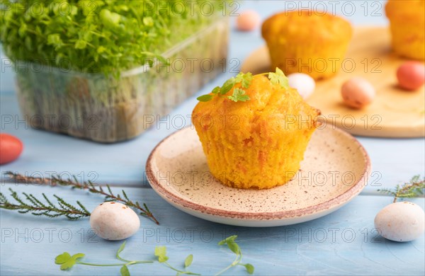 Homemade cakes with chocolate eggs and spinach microgreen on a blue wooden background. side view,